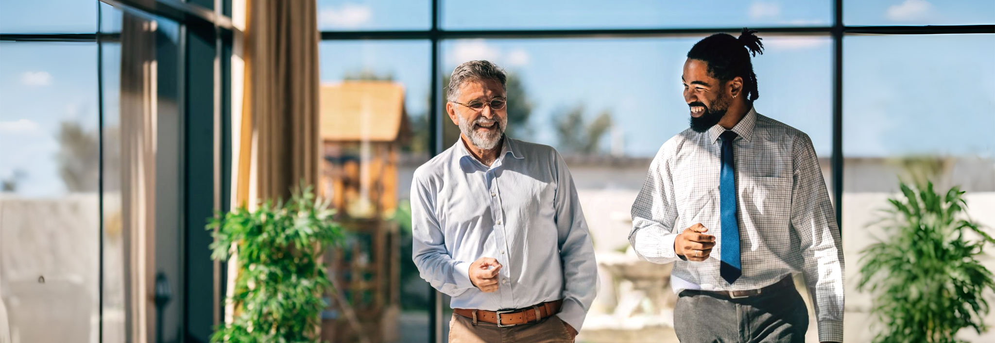 Two lawyers walking and talking in a sunlit office