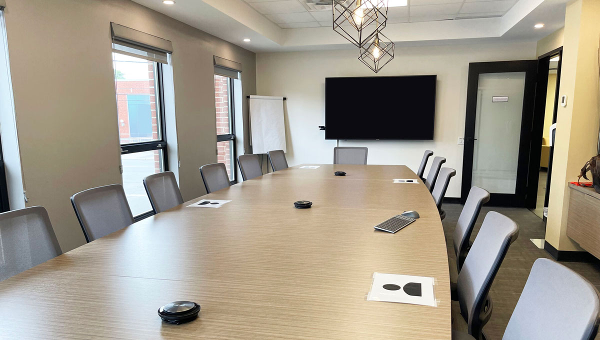 Boardroom with conference microphones on the table and a wall-mounted display