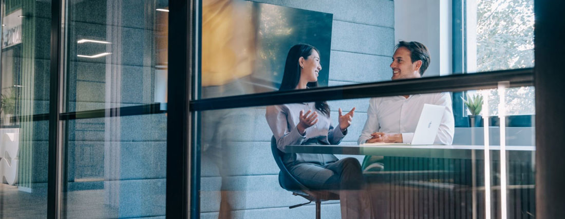 Two people discussing in a modern office setting