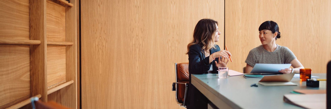 Two law firm professionals talking through an approach in a meeting room